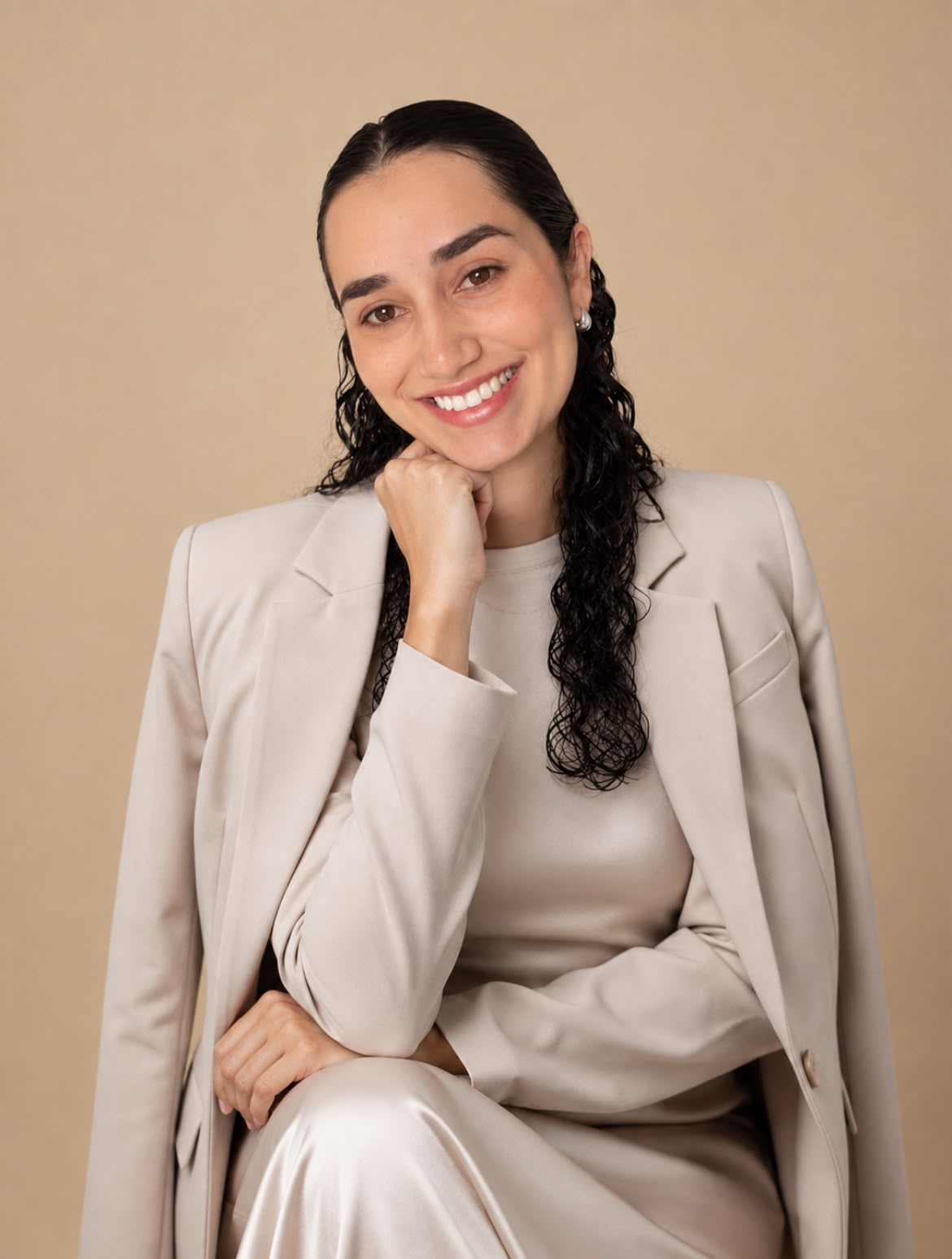 Jardiele Vilaço sentada, sorrindo, em traje bege